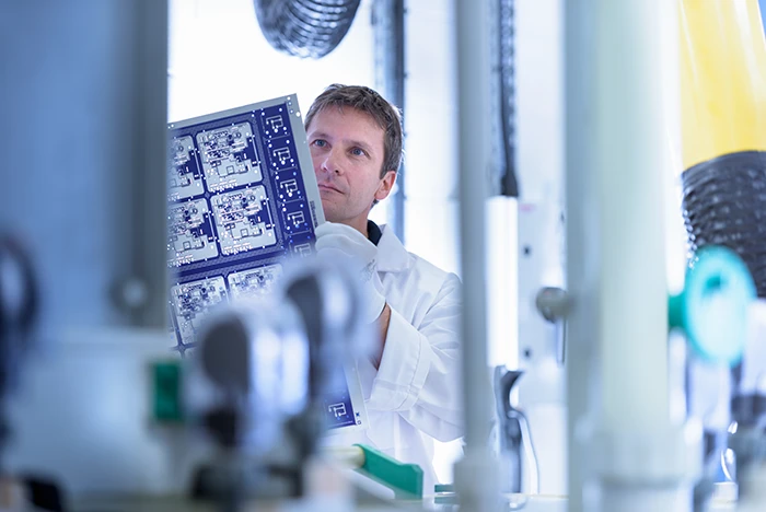 Worker Inspecting Circuit Board